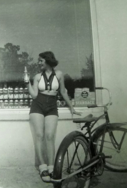 Bicyclist gets a refreshing soda at Store, August 1955